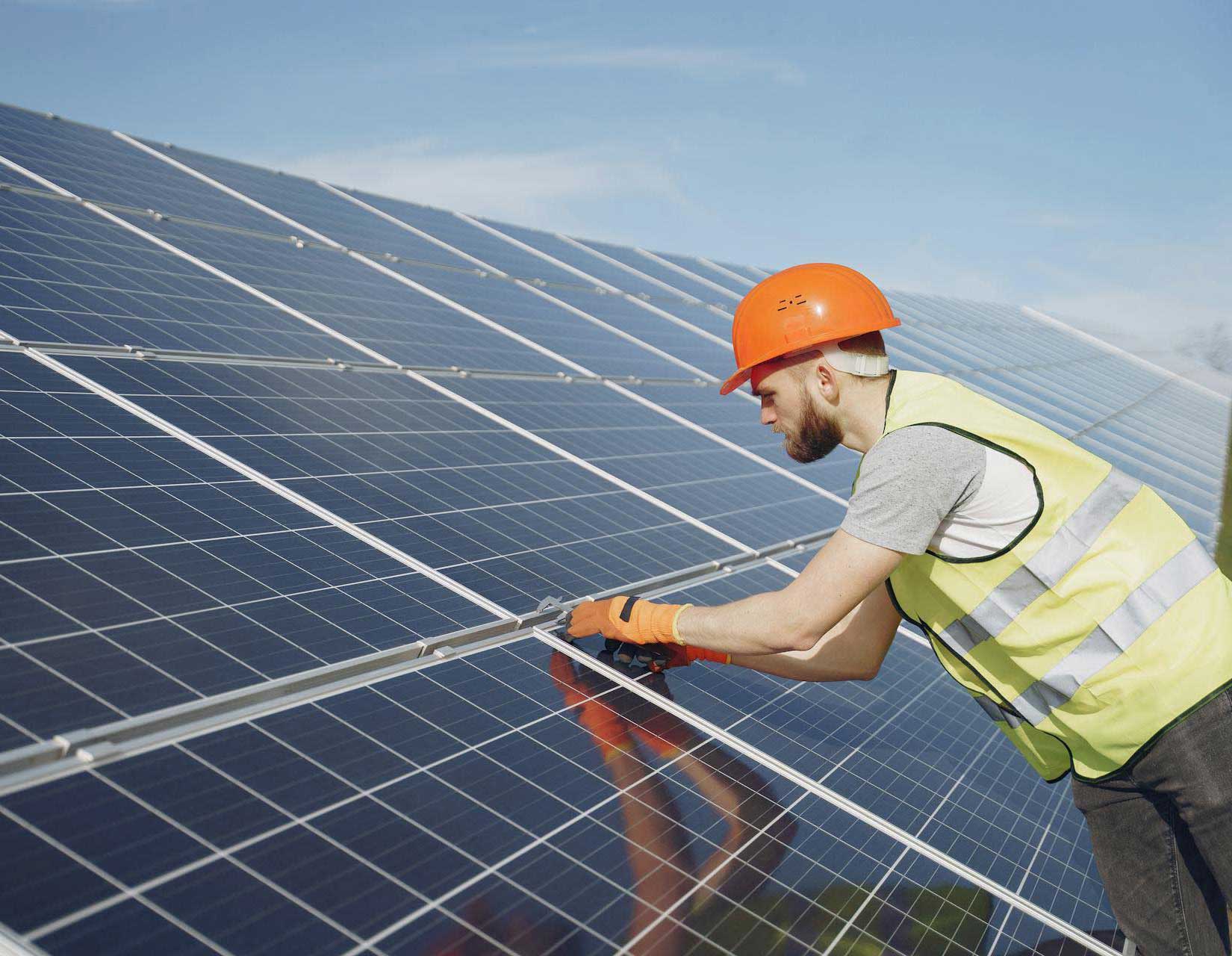 MarVal Power technician in hi-vis installing commercial solar panels